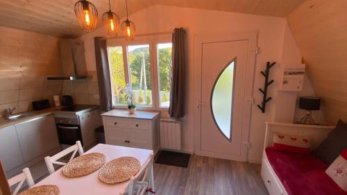 d'une cuisine et d'une salle à manger avec une table et une fenêtre. dans l'établissement Au-Doux-Altic chalet romantique avec JACUZZI ET SAUNA, à Métabief