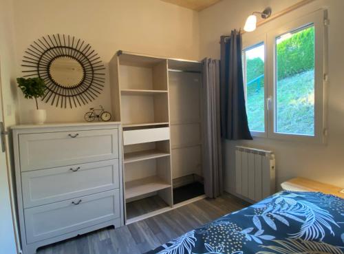 a bedroom with a bed and a dresser and a window at Au-Doux-Altic chalet romantique avec JACUZZI ET SAUNA in Métabief