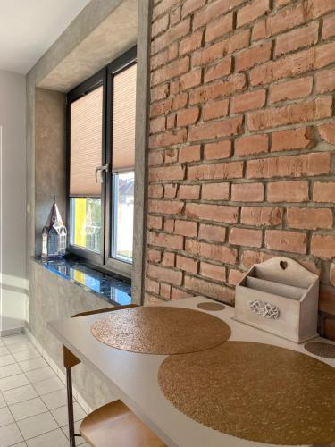 a brick wall in a room with a table at Empero Apartments Bardejov 1 in Bardejov