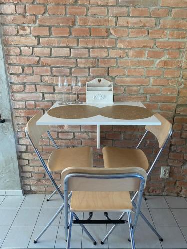 a table and two chairs in front of a brick wall at Empero Apartments Bardejov 1 in Bardejov