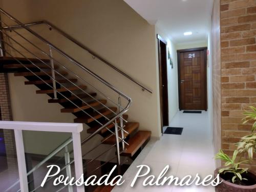 a staircase in a house with a brick wall at Pousada Palmares in Cabo Frio