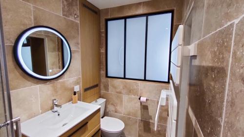 une salle de bain avec un lavabo et un miroir dans l'établissement Le Moulin Dort Hyper Centre Gare Disney, à Meaux