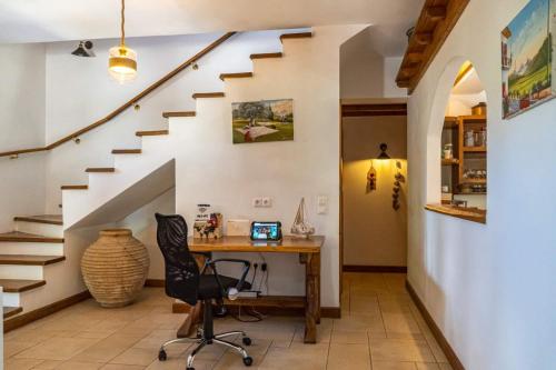 a home office with a desk and stairs at Platanos in Vasiliki