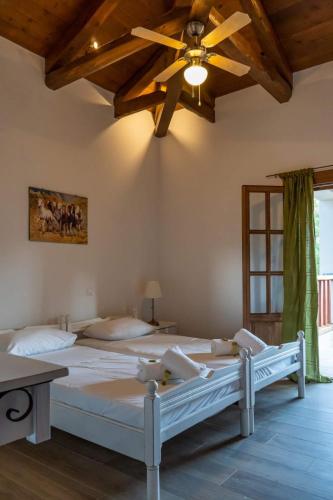 a bedroom with a large bed with a ceiling fan at Platanos in Vasiliki