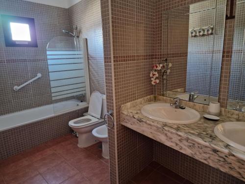 ein Badezimmer mit einem WC, einem Waschbecken und einer Badewanne in der Unterkunft Villa Georgiana - 4 Bed Property with private pool in Playa Blanca