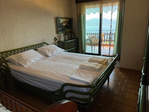 1 cama en un dormitorio con vistas a un balcón en Holiday Home With Unique Views And Private Garden, en Kalamos
