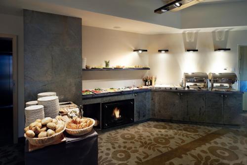 una cocina con chimenea en el centro de una cocina en Aparthotel Cristal Resort Szklarska Poręba by Zdrojowa, en Szklarska Poręba