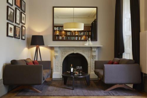 a living room with two couches and a fireplace at Malmaison Cheltenham in Cheltenham