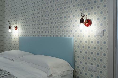 a bedroom with a white bed and two lights at La Dimora del Principe in Bagnoregio