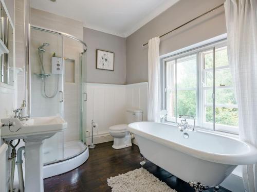 a bathroom with a tub and a sink and a toilet at Spire View in Wilton