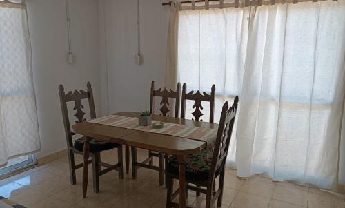 a wooden table and chairs in a room with a window at Laprida in Curuzú Cuatiá