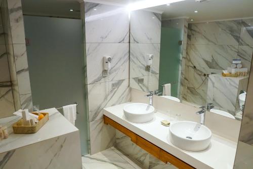a bathroom with two sinks and a mirror at Hotel Parada Linares in Linares