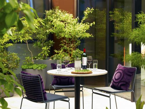 a table with purple chairs and a bottle of wine at Malmaison Cheltenham in Cheltenham