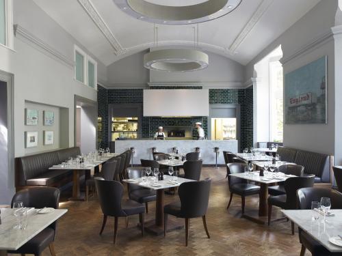 un restaurant avec des tables et des chaises et un plafond blanc dans l'établissement Malmaison Cheltenham, à Cheltenham