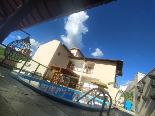 uma piscina em frente a uma casa com escorrega aquático em Maravilhosa casa c/ piscina em Capitólio-MG em Capitólio