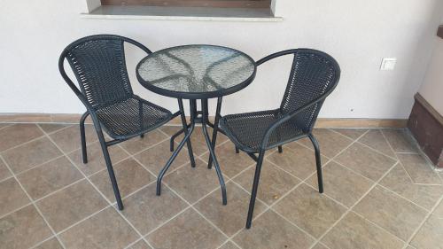 two black chairs and a table with a glass top at Tölgyeserdő Birtok Kaba Szállás és rendezvény in Kaba