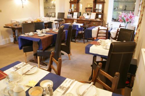 een eetkamer met tafels en stoelen met gerechten erop bij Bellevue Guest House in Kelso