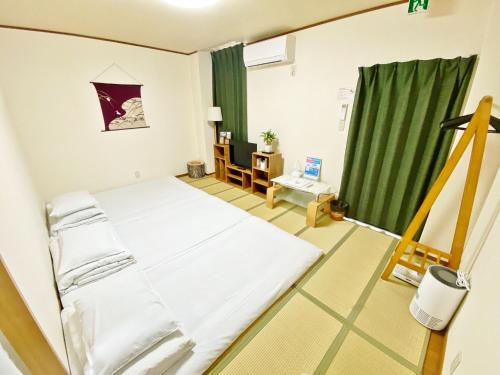 a bedroom with a bed and a green curtain at Petit Hotel 017 - Vacation STAY 36979v in Tokushima
