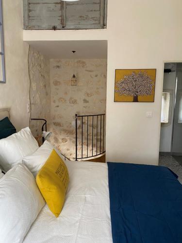 - une chambre avec un lit doté d'un oreiller jaune dans l'établissement LA PETITE MAISON DE MAUSSANE ***, à Maussane-les-Alpilles