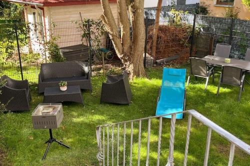 einen Garten mit Stühlen, einem Tisch und einem Grill in der Unterkunft Schmuckstück im Herzen Rostocks mit grüner Oase in Rostock