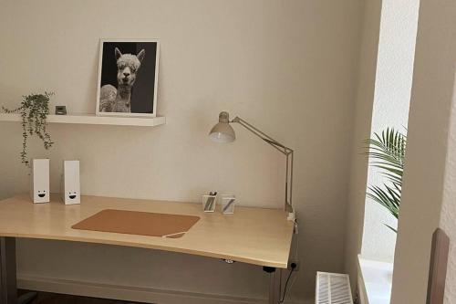 a desk with a picture of a dog on the wall at Schmuckstück im Herzen Rostocks mit grüner Oase in Rostock