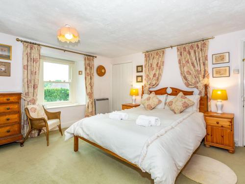 a bedroom with a large bed with two towels on it at Corner House in Grinton