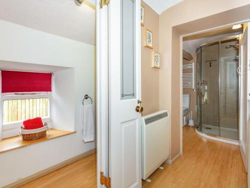 a bathroom with a walk in shower and a window at Corner House in Grinton