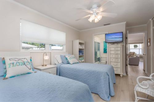 een slaapkamer met 2 bedden en een flatscreen-tv bij Crystal Sands & Dreams in Sarasota