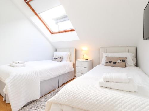 ケズウィックにあるSky Viewの天窓付きの屋根裏部屋のベッドルームにベッド2台が備わります。