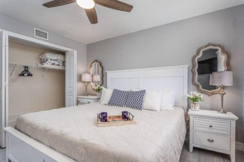 um quarto com uma grande cama branca e um espelho em Minorga on the Gulf em Siesta Key