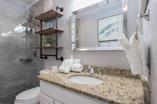 uma casa de banho com um lavatório, um WC e um espelho. em Minorga on the Gulf em Siesta Key