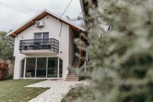 uma casa branca com uma varanda e uma escadaria em Sunrise Riverside House em Čelarevo