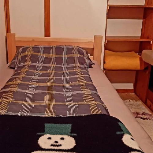 Una cama con una manta con un oso. en Oaza Mira-vikend kuca sa bazenom, en Pale