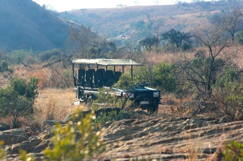a jeep with seats in a field on a hill at Esiweni Luxury Safari Lodge in Nambiti Private Game Reserve