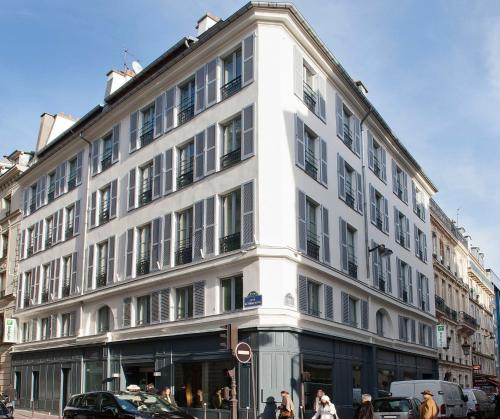 a white building with people walking in front of it at Holiday Inn Paris Elysées, an IHG Hotel in Paris