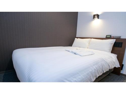 ein Schlafzimmer mit einem weißen Bett mit weißer Bettwäsche in der Unterkunft ＹＯＵ ＳＴＹＬＥ ＨＯＴＥＬ ＨＡＫＡＴＡ - Vacation STAY 16027v in Fukuoka