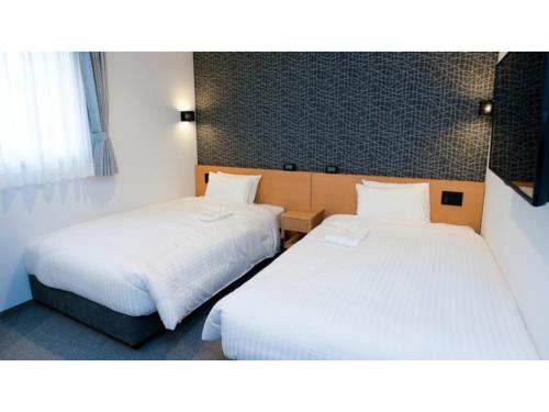 2 łóżka w pokoju hotelowym z białą pościelą w obiekcie ＹＯＵ ＳＴＹＬＥ ＨＯＴＥＬ ＨＡＫＡＴＡ - Vacation STAY 16033v w mieście Fukuoka