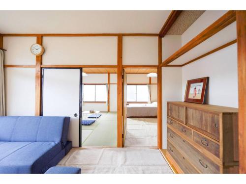 a living room with a blue couch and a mirror at Second House Nikko - Vacation STAY 13408 in Nikko