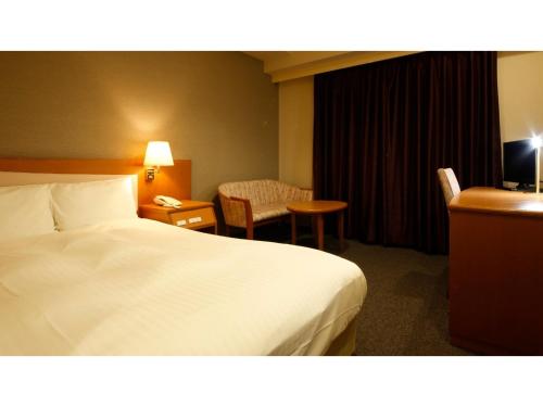 una camera d'albergo con un letto bianco e una sedia di Ako onsen AKO PARK HOTEL - Vacation STAY 21611v ad Ako