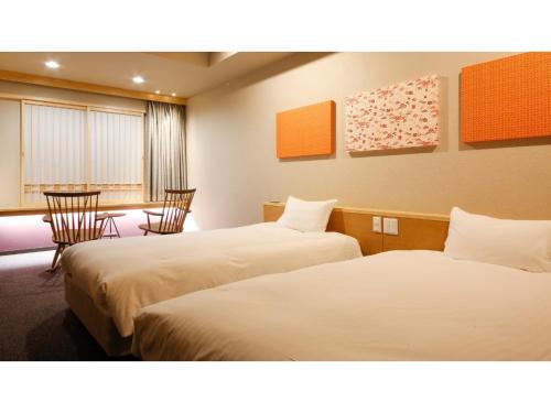 Habitación de hotel con 2 camas, mesa y sillas en Ako onsen AKO PARK HOTEL - Vacation STAY 21683v, en Ako