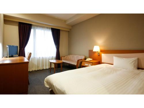 una camera d'albergo con un letto, una sedia e una finestra di Ako onsen AKO PARK HOTEL - Vacation STAY 21595v ad Ako