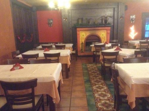 a restaurant with white tables and a fire place at Astrovolia in Pertouli