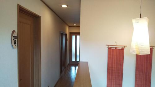 a hallway with a table and a chandelier at Guest House Nishimura - Vacation STAY 13436 in Kyoto