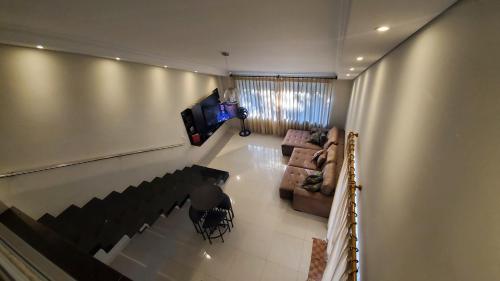 a person sitting in a living room with a television at Casa da lagoa in Porto Seguro