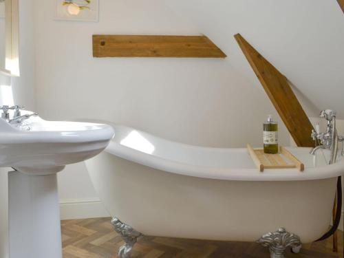 uma casa de banho com uma banheira e um lavatório em Printmakers Cottage em Bellanoch