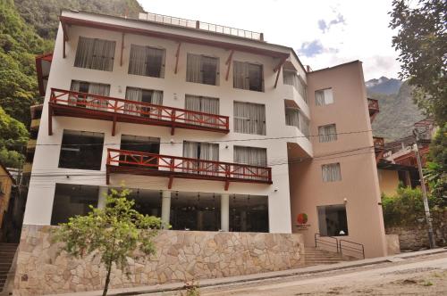 Un grand bâtiment blanc avec balcon est disponible. dans l'établissement Tierra Viva Machu Picchu Hotel, à Machu Picchu