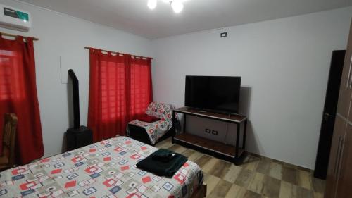 een slaapkamer met een bed en een flatscreen-tv bij Depto para turistas - Mago Blanco in Godoy Cruz