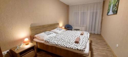 Un pequeño dormitorio con una cama con dos velas. en Park 84 Vendégház, en Vecsés