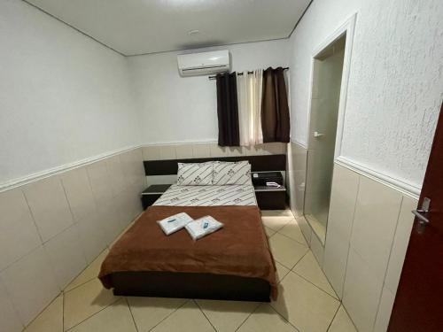 a small room with a bed and two books on it at Hotel Tenda Brigadeiro SP in Sao Paulo