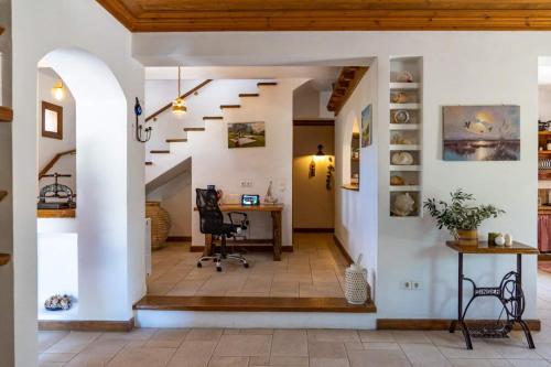 an open hallway with a desk and stairs in a house at Platanos in Vasiliki